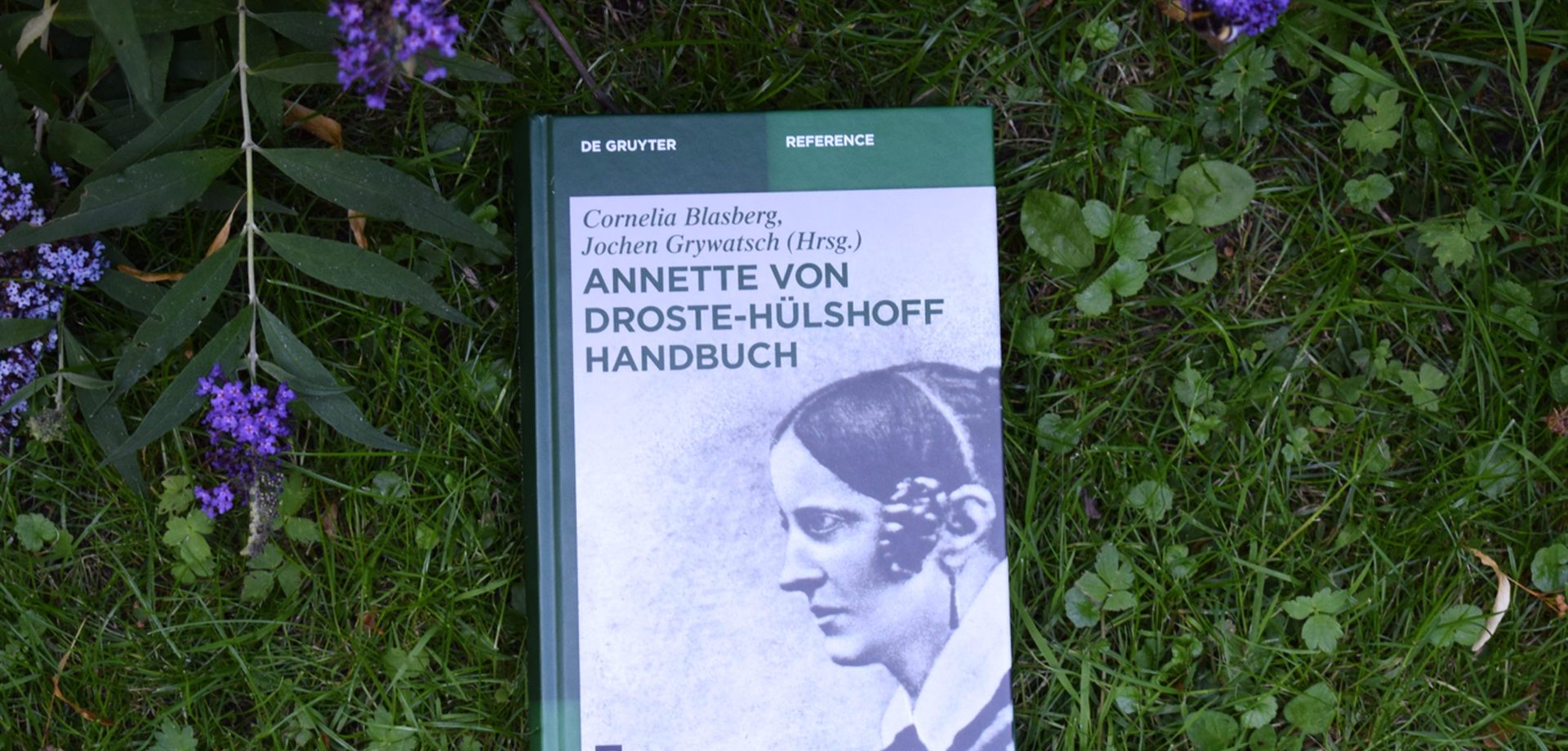Annette von Droste-Hülshoff Handbuch auf einer Wiese, © Droste-Forschungsstelle